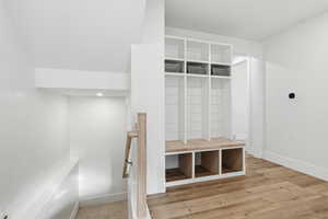 Mudroom with light wood finished floors and baseboards
