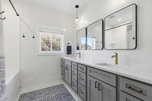 Bathroom with double vanity, shower / bath combo, and light tile patterned floors