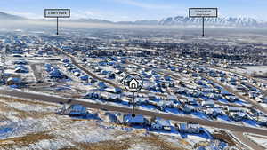 Snowy aerial view featuring a residential view and a mountain view