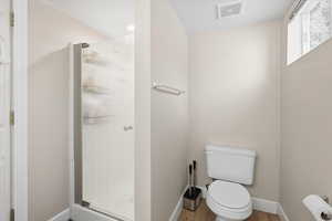 Downstairs Bathroom with a shower stall and wood finished floors