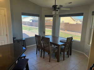 Dining room featuring light tile patterned floors, lofted ceiling, plenty of natural light, and ceiling fan