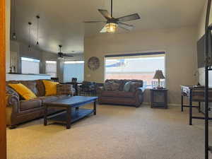 Living room with healthy amount of natural light, light colored carpet, and a ceiling fan