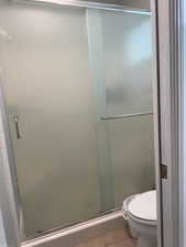 Bathroom featuring tile patterned flooring and a shower stall