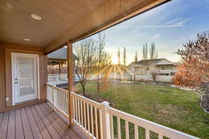 Wooden terrace with a fenced backyard