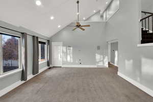 Unfurnished living room with carpet flooring, high vaulted ceiling, recessed lighting, a ceiling fan, and stairs