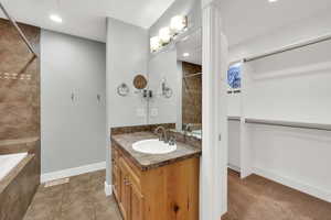 Full bathroom with vanity, recessed lighting, tiled bath, and light tile patterned floors