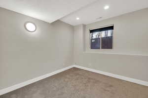 Empty room featuring baseboards and carpet flooring