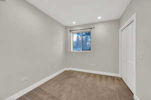 Unfurnished bedroom featuring carpet floors, a closet, and recessed lighting