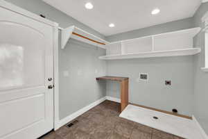 Laundry room with hookup for a washing machine, electric dryer hookup, recessed lighting, and dark tile patterned floors