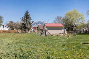 Fenced backyard with an outdoor structure and a mountain view