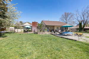 Back of house with a patio area and a yard