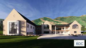 Rear view of property with a balcony, a yard, stucco siding, and a mountain view