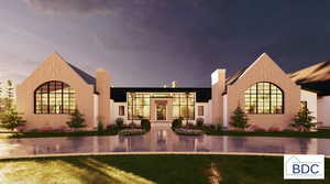 View of front of home featuring a chimney, a lawn, and stucco siding