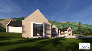 Back of property with a yard, a mountain view, and stucco siding