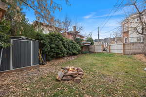 View of yard featuring a fire pit and a shed