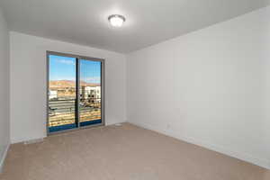 Empty room with light colored carpet and baseboards