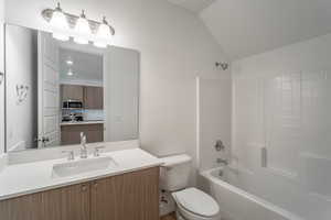 Full bathroom featuring lofted ceiling, vanity, and bathing tub / shower combination