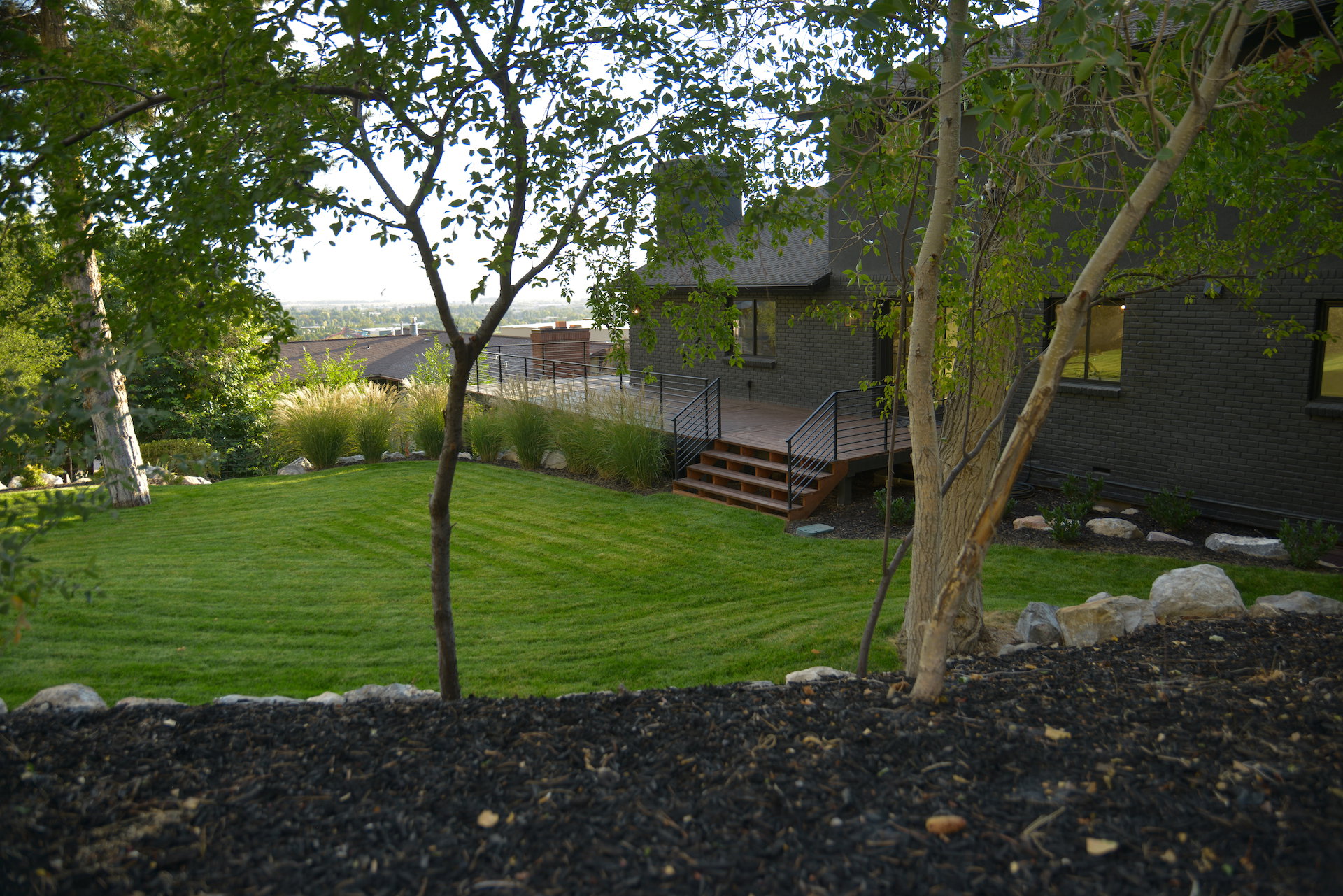 View of grassy yard featuring a deck