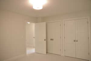 Unfurnished bedroom featuring two closets and carpet floors