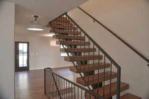 Staircase featuring wood finished floors and baseboards