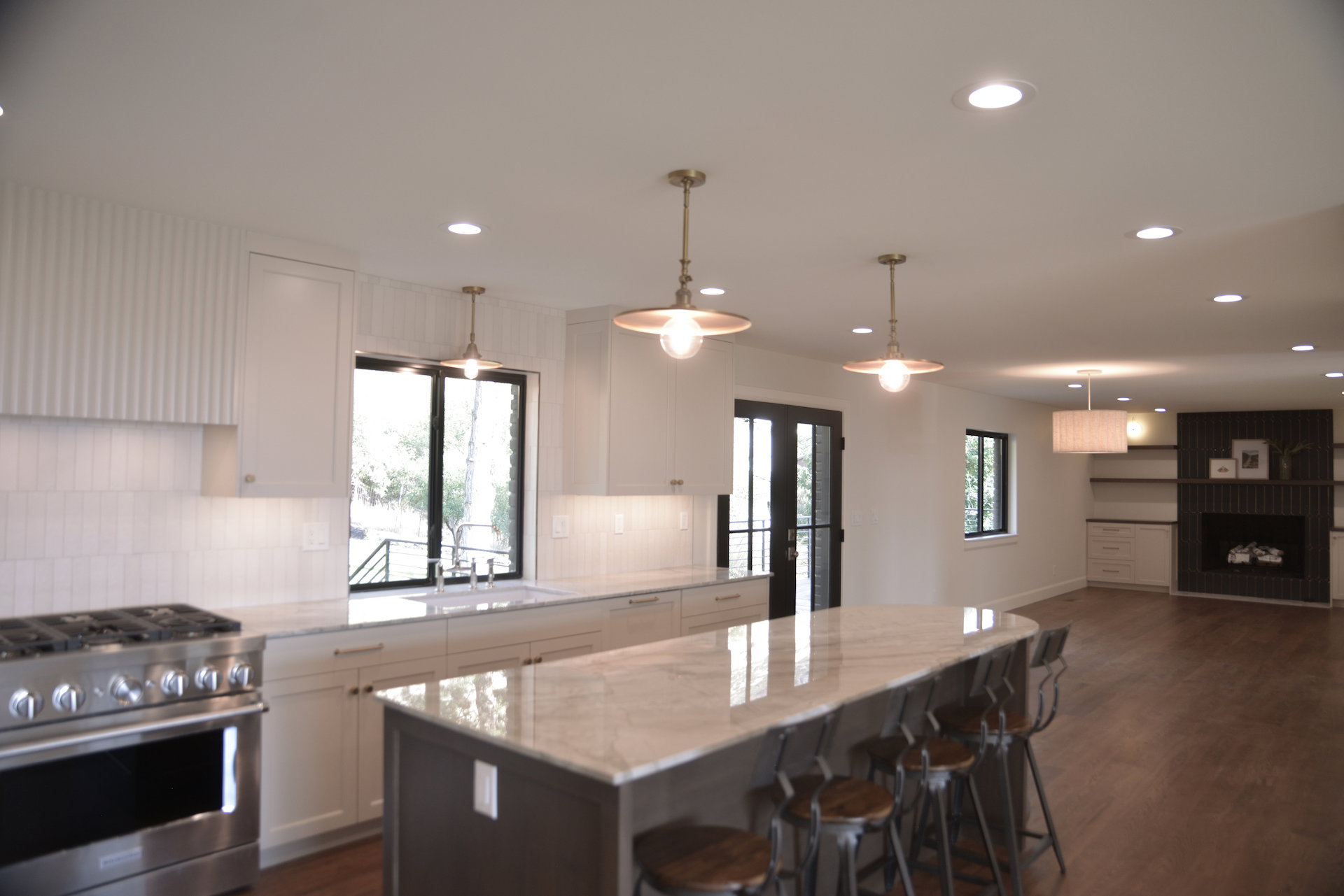 Kitchen with stainless steel gas range oven, white cabinets, decorative backsplash, dark wood finished floors, and recessed lighting