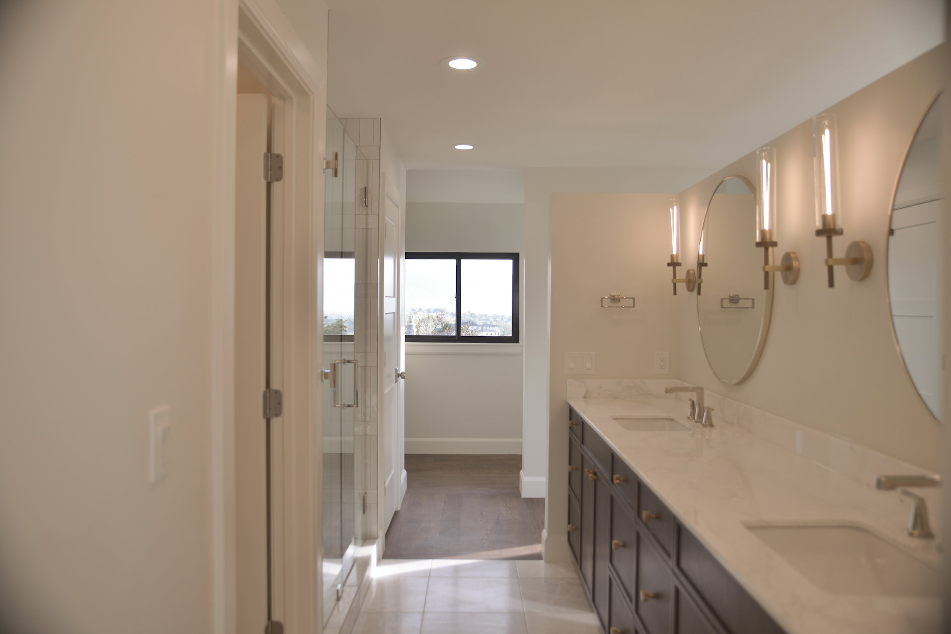 Bathroom featuring double vanity, a shower stall, light tile patterned floors, and recessed lighting