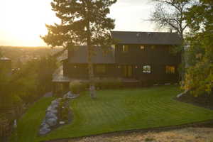 Rear view of property with a yard