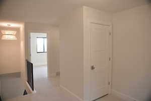 Corridor featuring light carpet and an upstairs landing