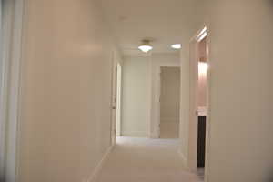 Hall with light carpet and baseboards
