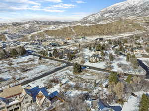 Snowy aerial view featuring a mountain view and a residential view