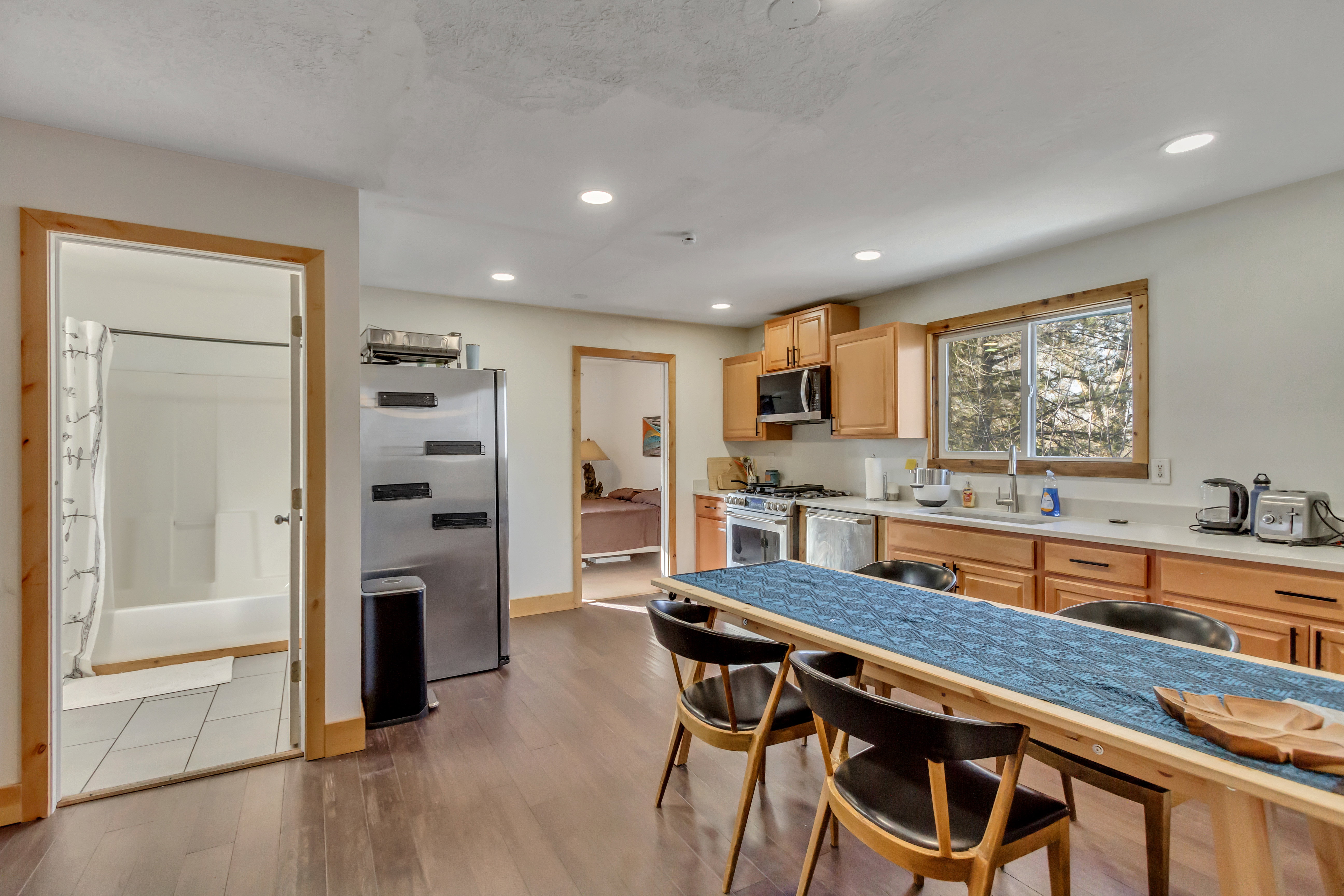 Kitchen with light brown cabinets, stainless steel appliances, light countertops, dark wood finished floors, and recessed lighting