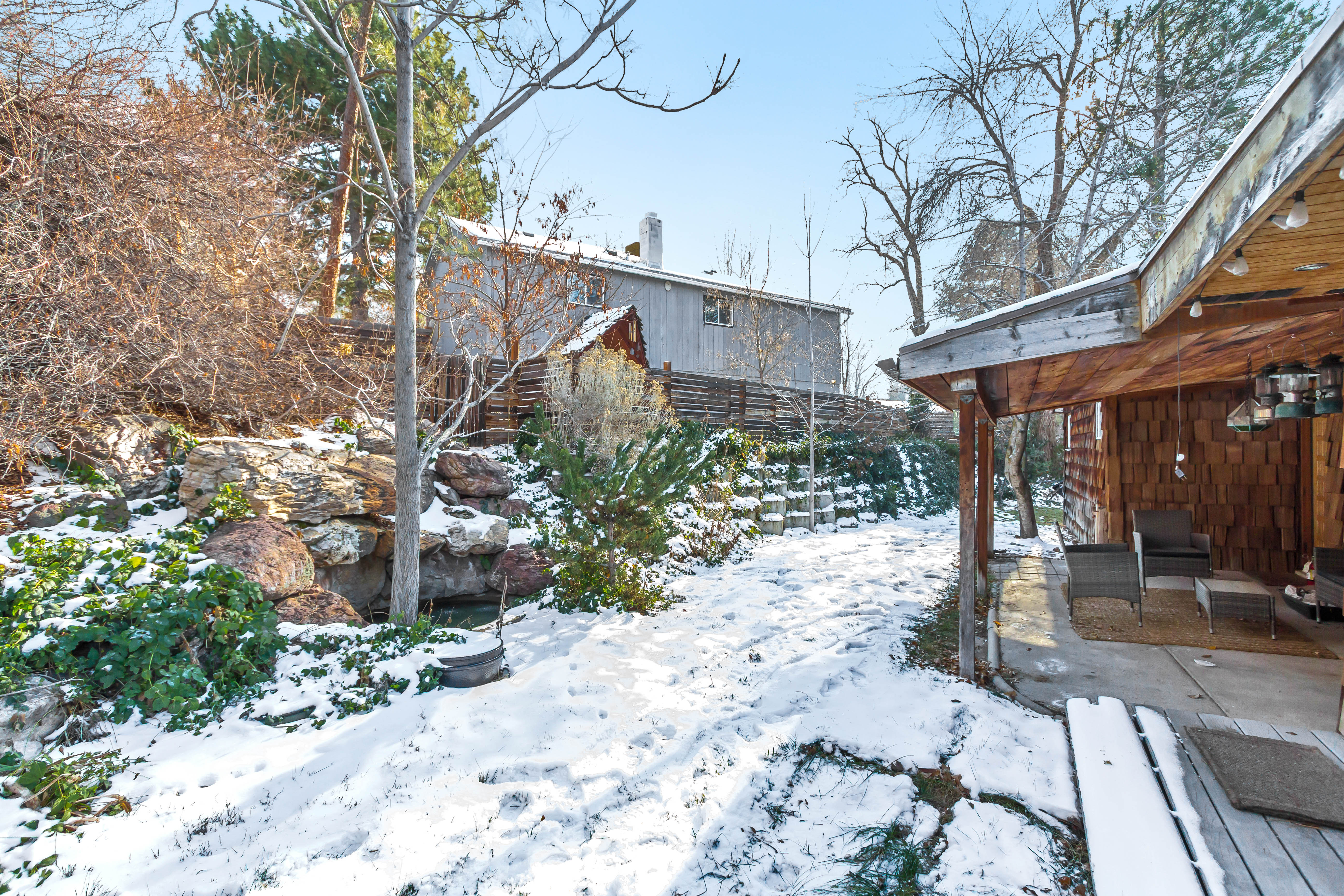 Yard layered in snow featuring a patio