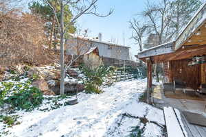 Yard layered in snow featuring a patio