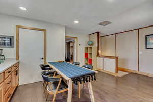 Dining space with light wood-style floors and recessed lighting