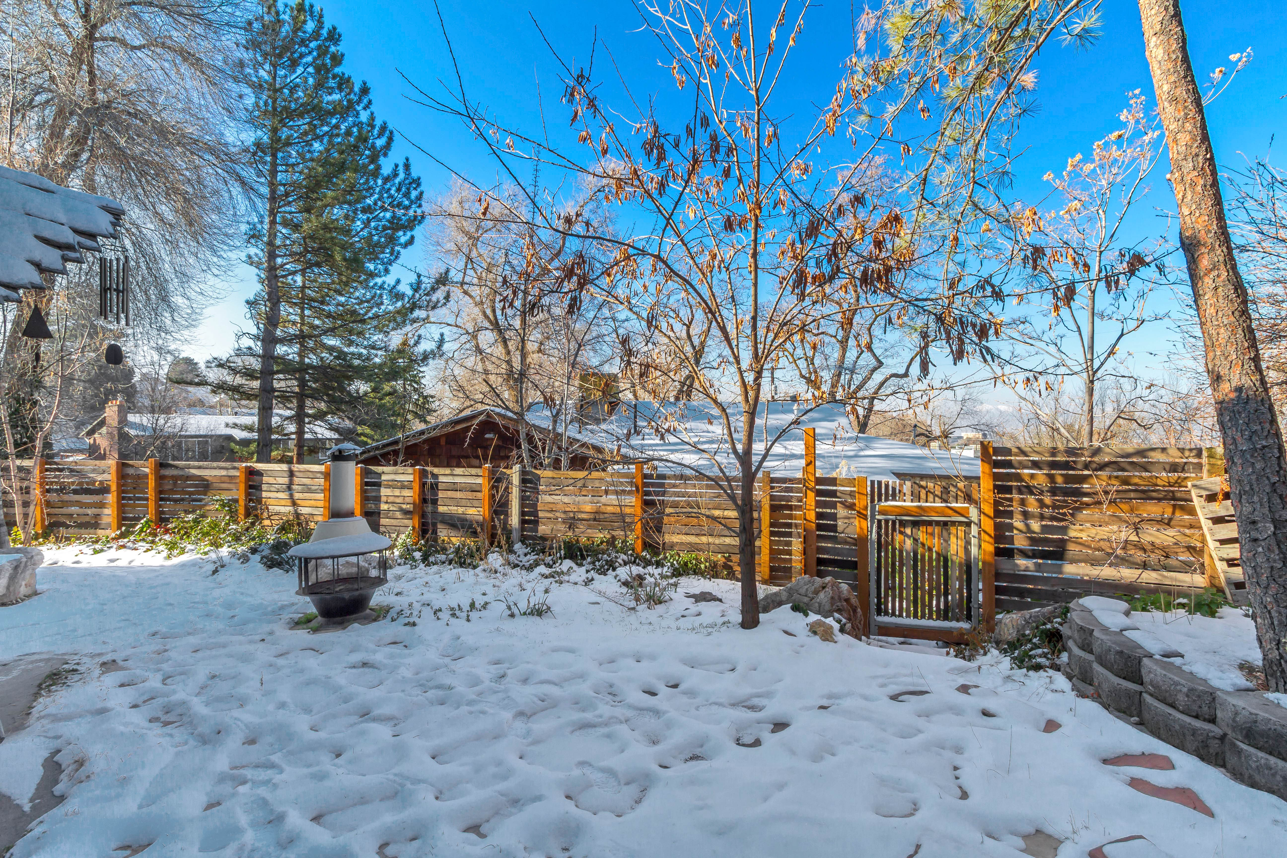 Snowy yard featuring a fenced backyard