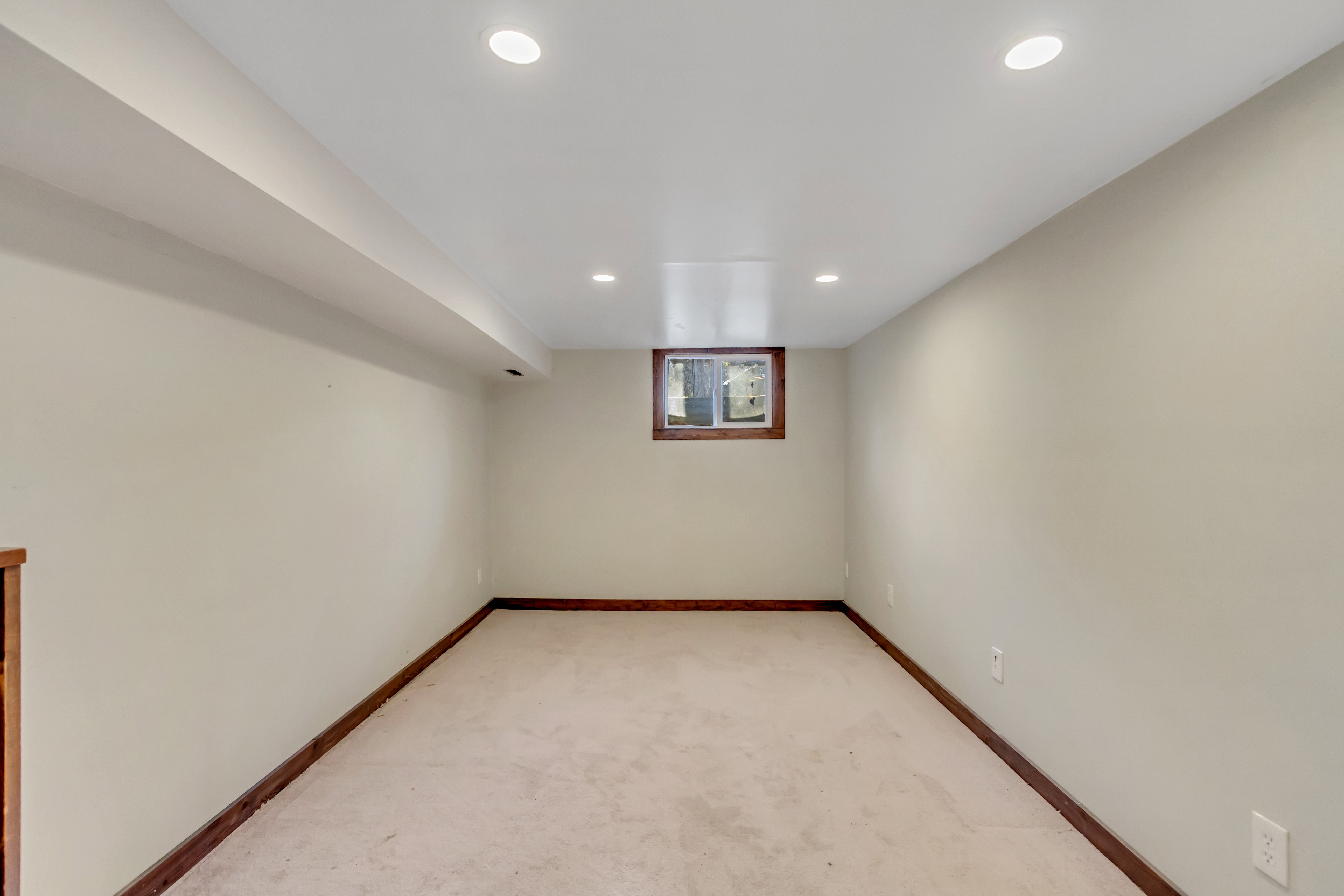 Below grade area featuring light colored carpet and recessed lighting