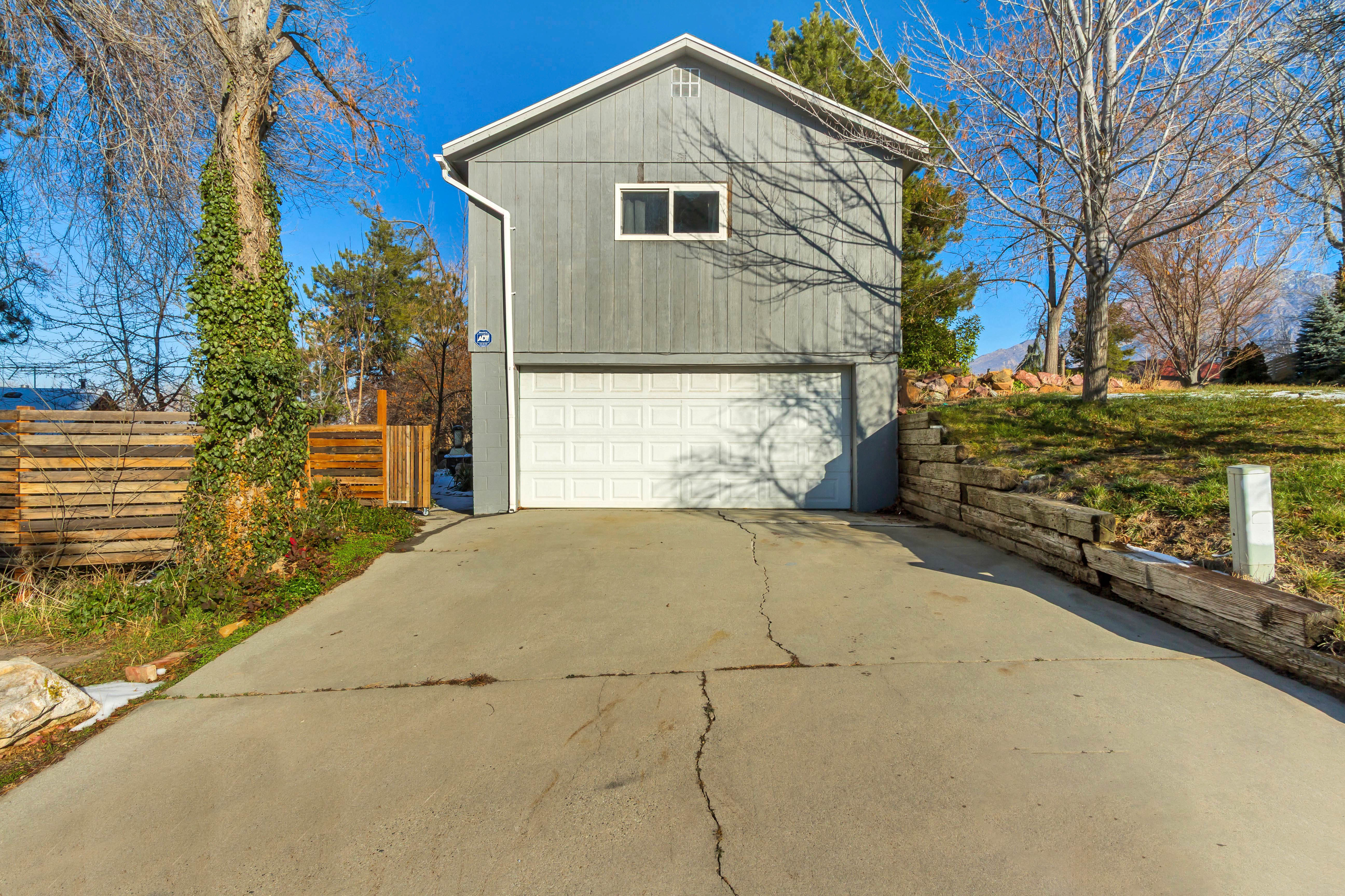 View of side of home with driveway and a garage