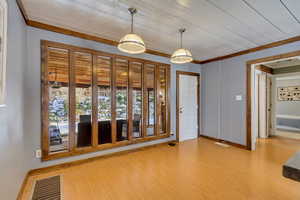 Foyer with wood finished floors, crown molding, and wooden ceiling
