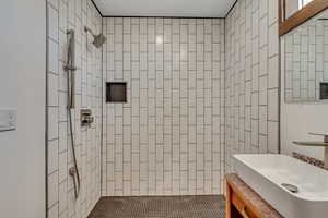 Bathroom featuring vanity and tiled shower