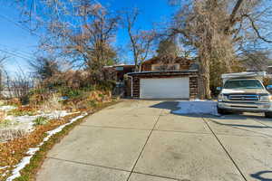 View of property exterior featuring a garage and concrete driveway