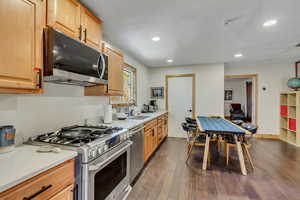 Kitchen with appliances with stainless steel finishes, dark wood-style floors, recessed lighting, and light brown cabinets