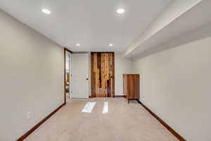 Carpeted empty room with baseboards and recessed lighting