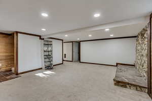 Finished below grade area with wood walls, carpet flooring, and recessed lighting