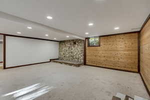 Basement featuring wooden walls, recessed lighting, and carpet flooring