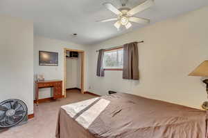 Bedroom featuring a closet, a ceiling fan, and light colored carpet