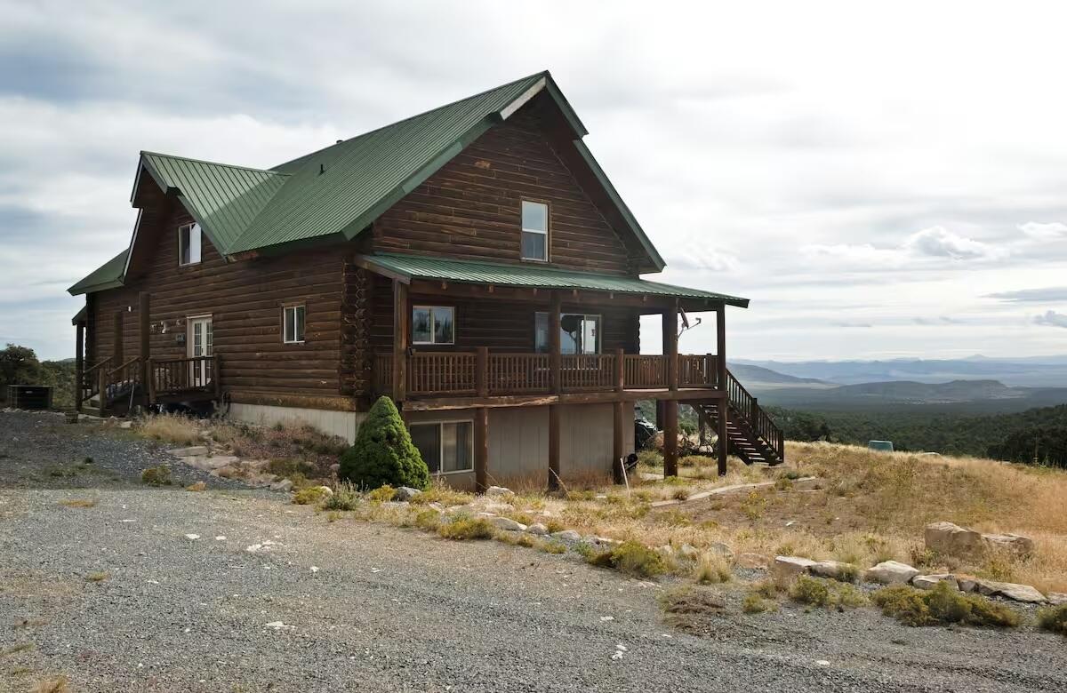 View of home's exterior with stairway, covered porch, a metal roof, and log exterior