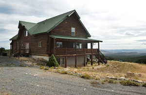 View of home's exterior with stairway, covered porch, a metal roof, and log exterior