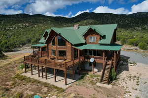 Rear view of property featuring a chimney, a metal roof, a mountain view, and a porch