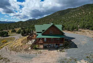 View of front of house featuring a deck with mountain view, stairway, and a metal roof