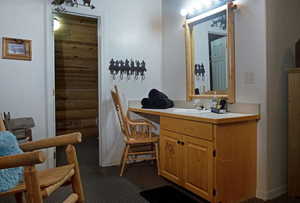 Bathroom with vanity and dark colored carpet